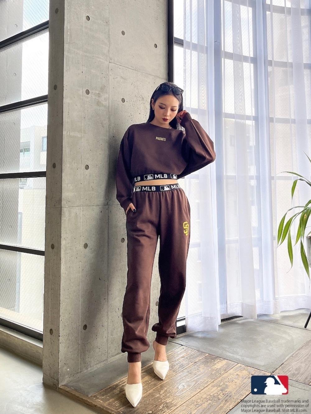 ブラウン系のスウェット、ブラウン系のスウェットパンツ、ホワイト系のパンプスを着用したレディースの春コーディネートの2枚目の写真