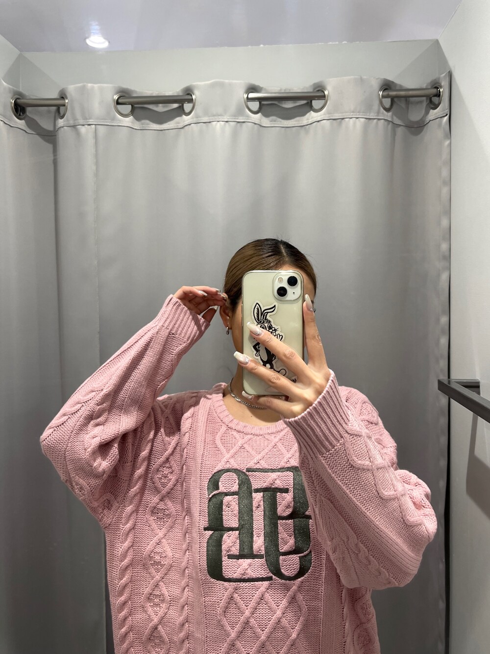 ピンク系のニット/セーター、ブラック系のデニムパンツ、ブラック系のブーツを着用したレディースの秋コーディネートの2枚目の写真
