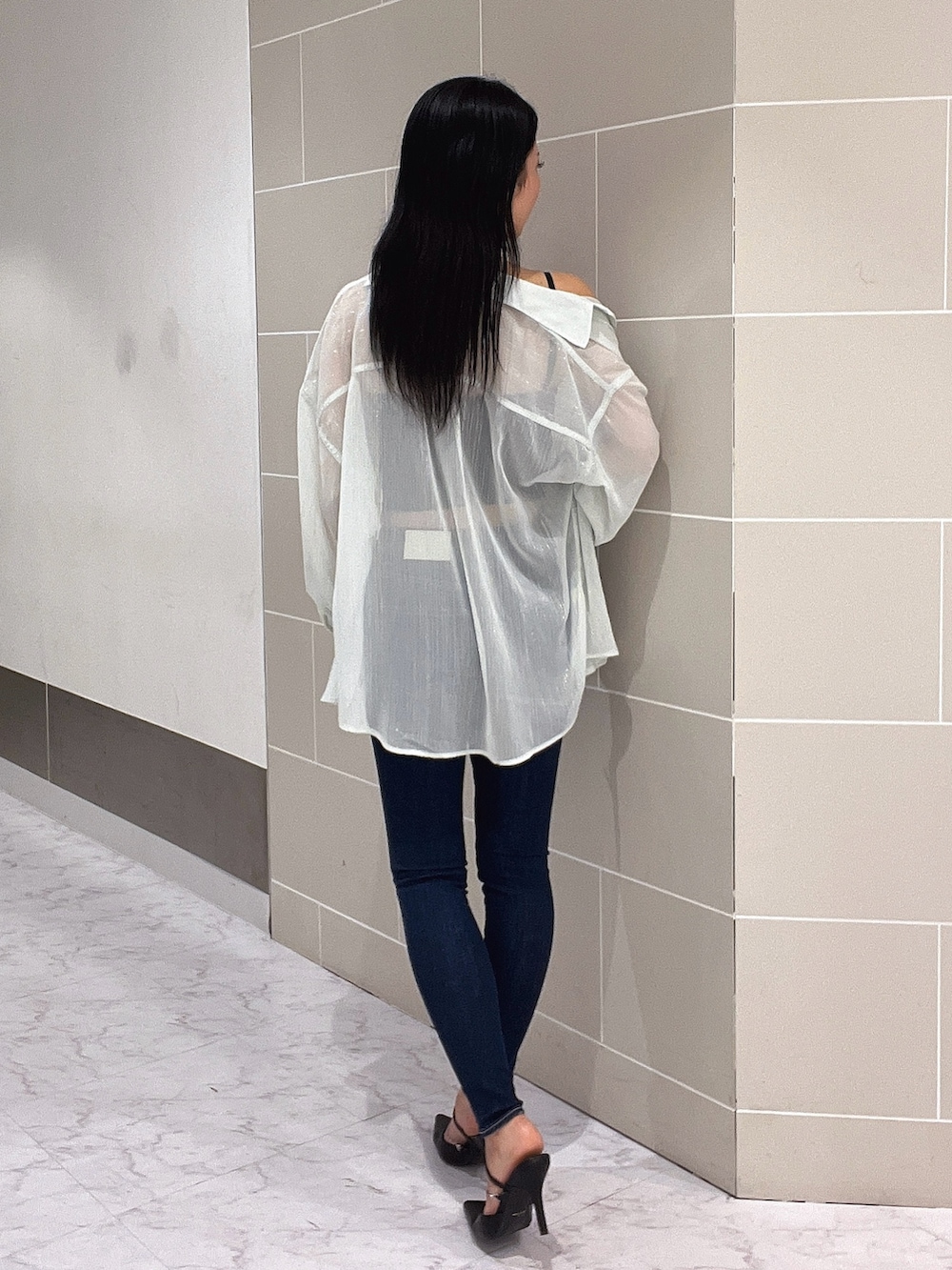 ブラック系のキャミソール、ブルー系のデニムパンツ、ブラック系のパンプスを着用したレディースの春コーディネートの5枚目の写真