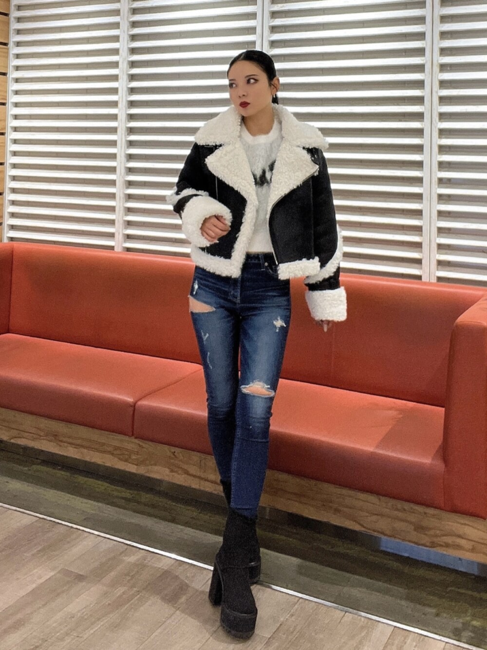 ホワイト系のニット/セーター、ブルー系のデニムパンツ、ブラック系のブーツを着用したレディースの秋コーディネートの2枚目の写真