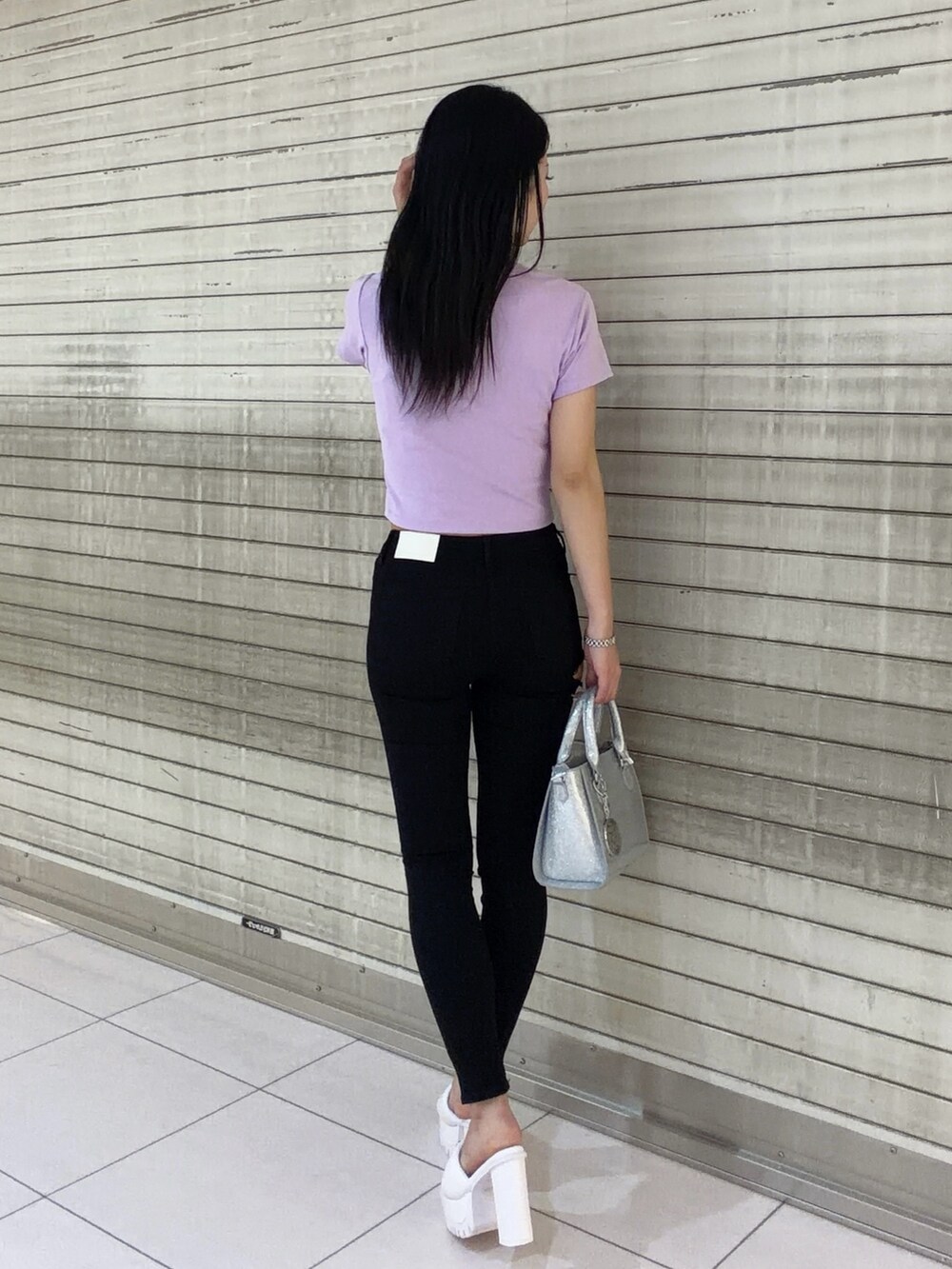 パープル系のTシャツ/カットソー、ブラック系のデニムパンツ、シルバー系のハンドバッグを着用したレディースの春コーディネートの4枚目の写真