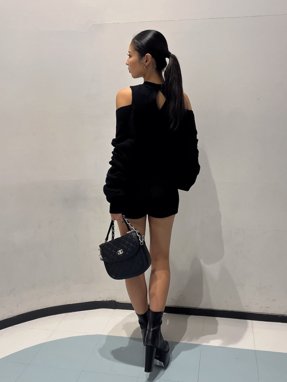 ブラック系のブーツ、ブラック系のハンドバッグ、ブラック系のつなぎ/オールインワンを着用したレディースの秋コーディネートの4枚目の写真