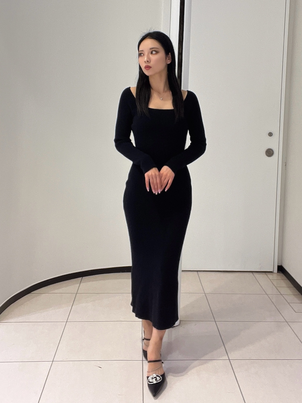 ブラック系のワンピース、ブラック系のパンプスを着用したレディースの春コーディネートの2枚目の写真