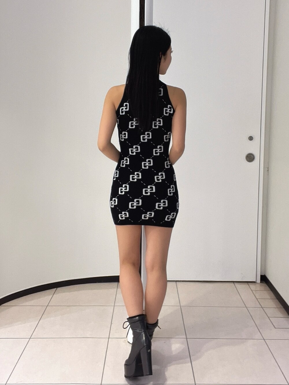 ブラック系のブーツ、ブラック系のワンピースを着用したレディースの春コーディネートの4枚目の写真