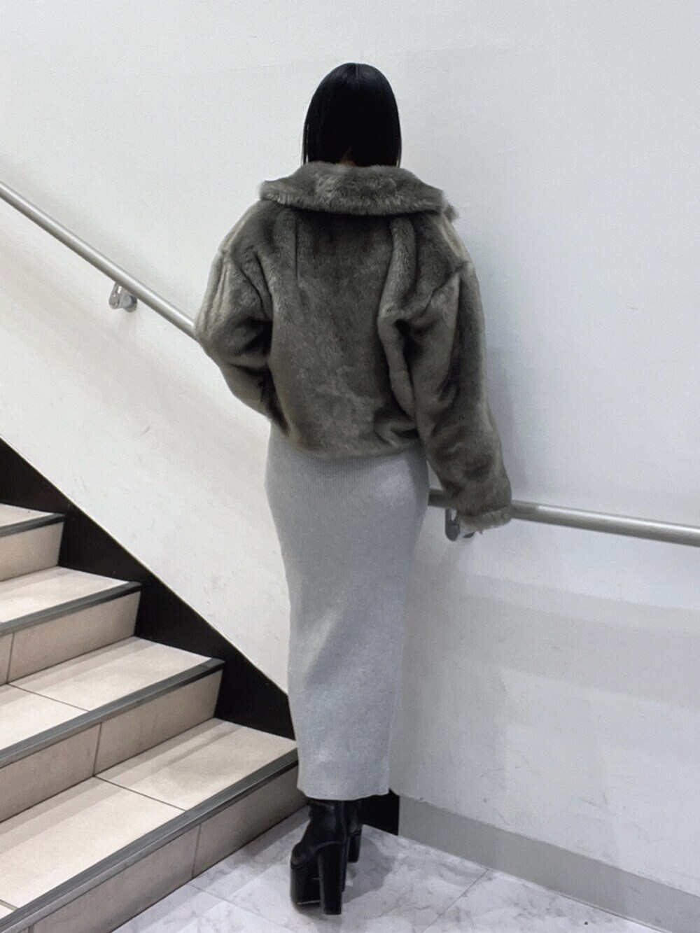 ブラック系のブーツ、グレー系のワンピースを着用したレディースの冬コーディネートの4枚目の写真