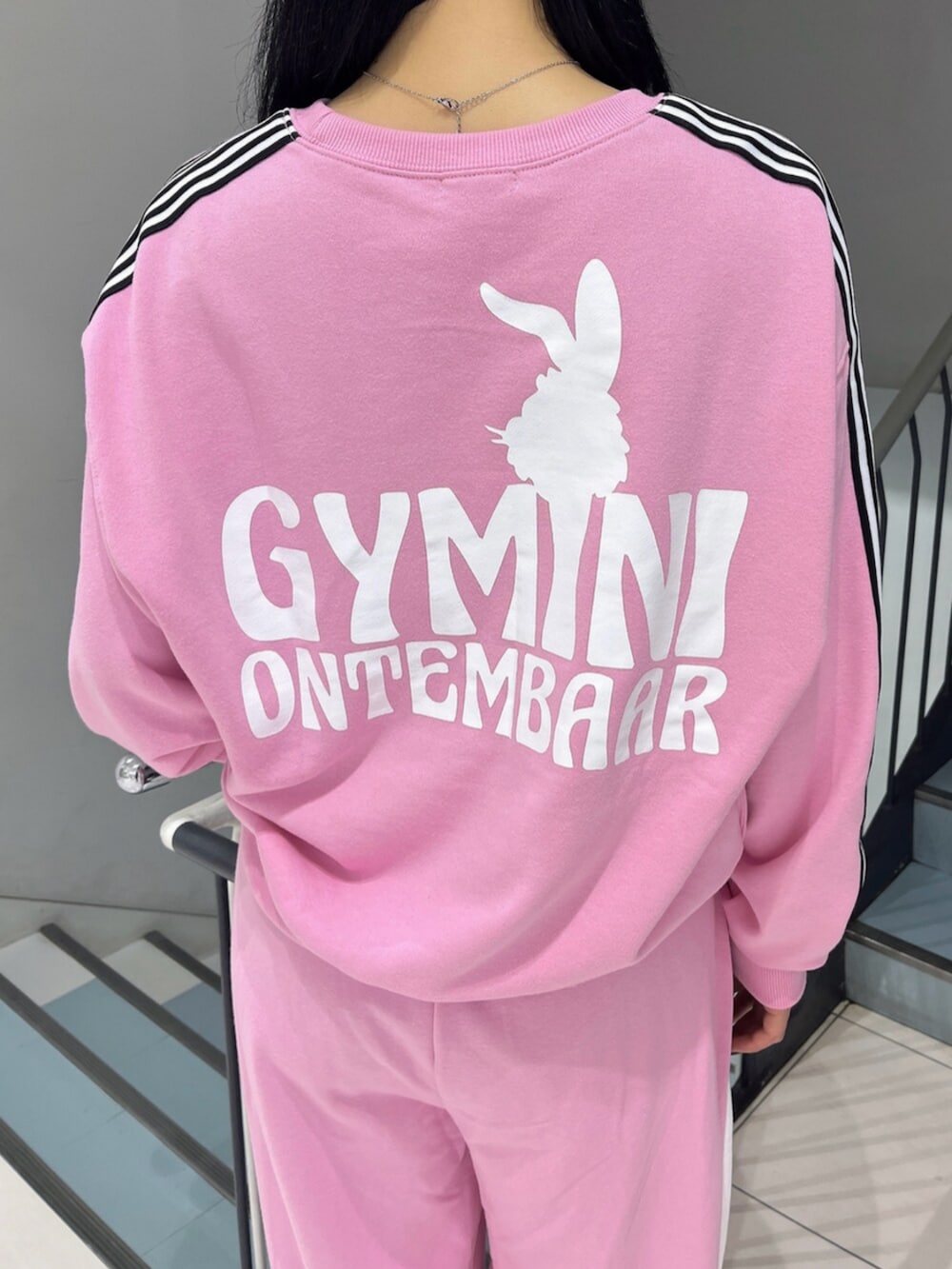 ブラック系のブーツ、ピンク系のスウェット、ピンク系のスウェットパンツを着用したレディースの冬コーディネートの8枚目の写真