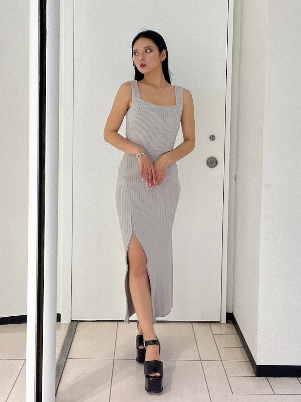 グレー系のワンピース、ブラック系のサンダルを着用したレディースの春コーディネートの3枚目の写真