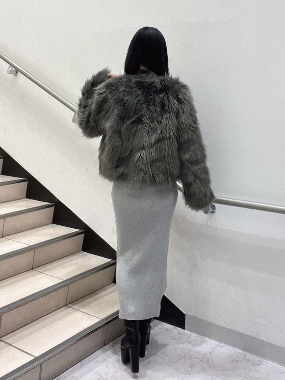 ブラック系のブーツ、グレー系のワンピース、グレー系のライダースジャケットを着用したレディースの冬コーディネートの4枚目の写真