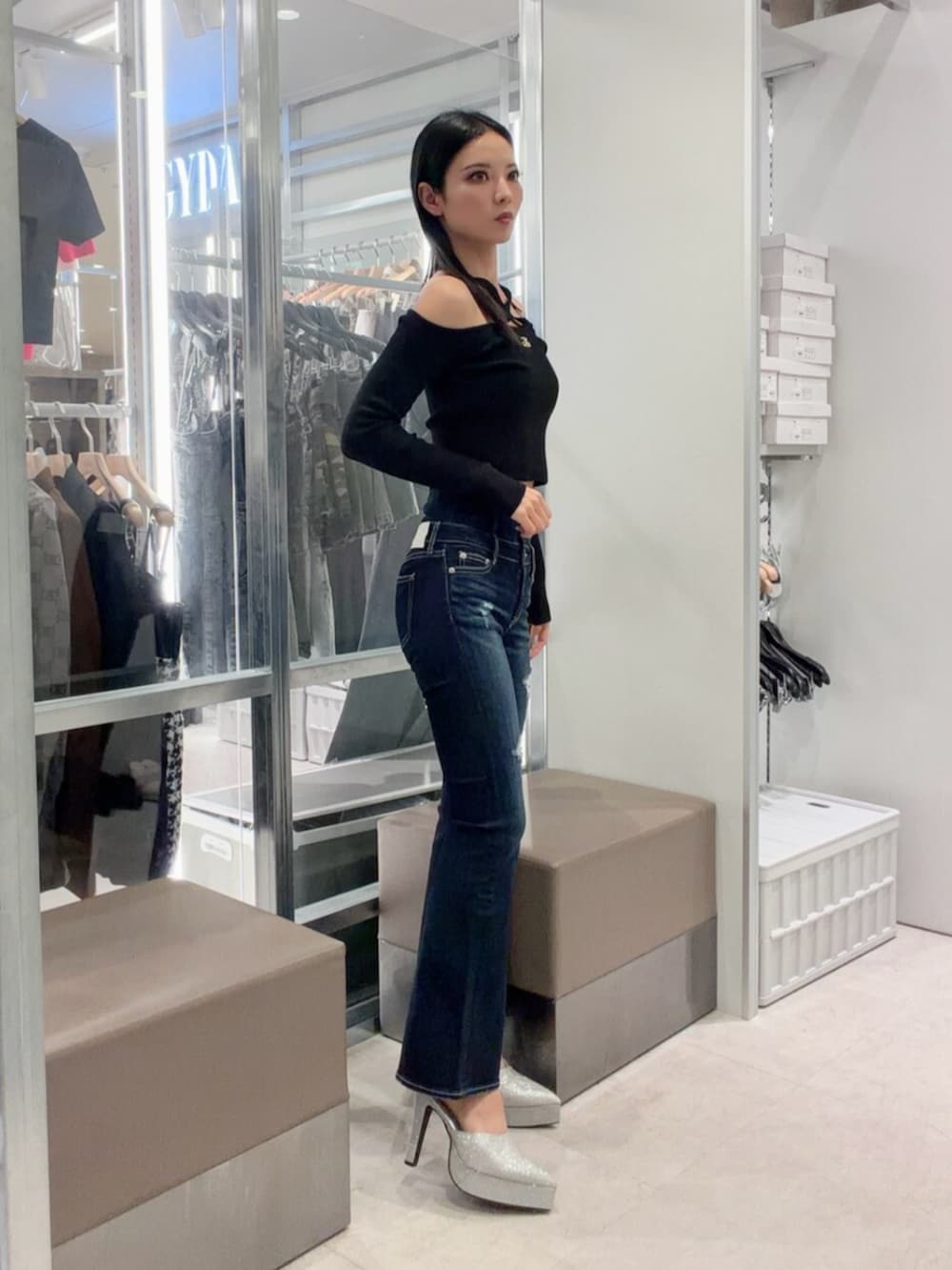 シルバー系のパンプス、ブルー系のデニムパンツ、ブラック系のニット/セーターを着用したレディースの秋コーディネートの3枚目の写真