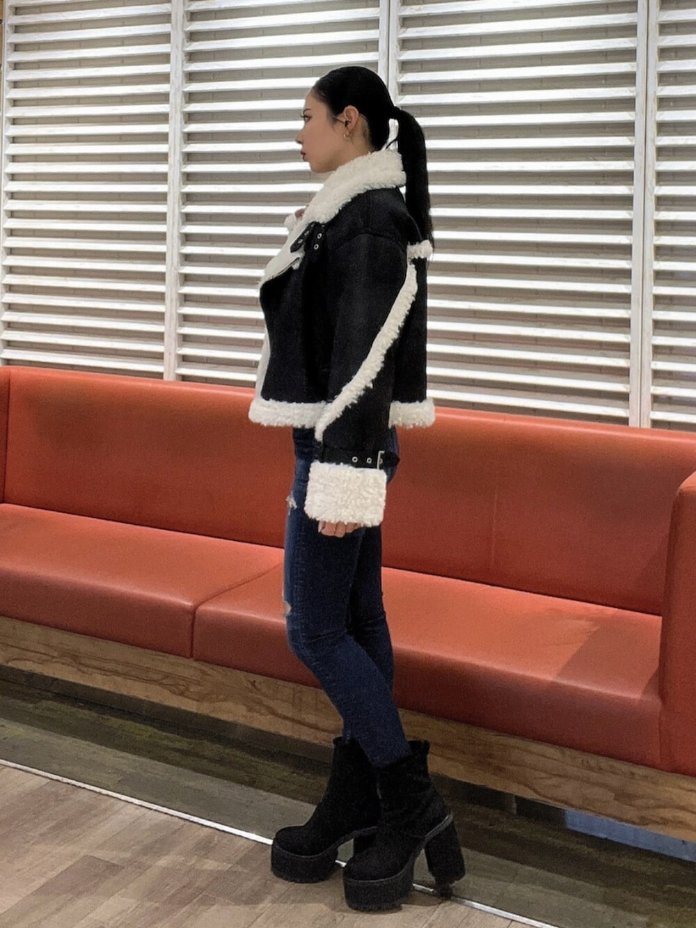 ホワイト系のニット/セーター、ブルー系のデニムパンツ、ブラック系のブーツを着用したレディースの秋コーディネートの3枚目の写真