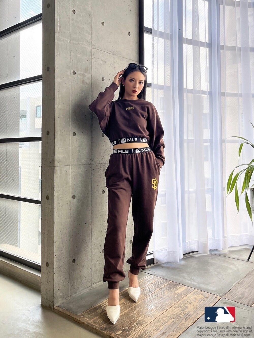 ブラウン系のスウェット、ブラウン系のスウェットパンツ、ホワイト系のパンプスを着用したレディースの春コーディネートの3枚目の写真