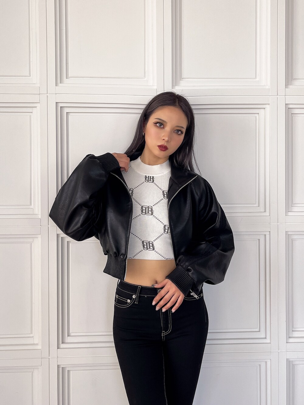 ホワイト系のニット/セーター、ブラック系のブルゾン、ブラック系のデニムパンツを着用したレディースの冬コーディネートの3枚目の写真