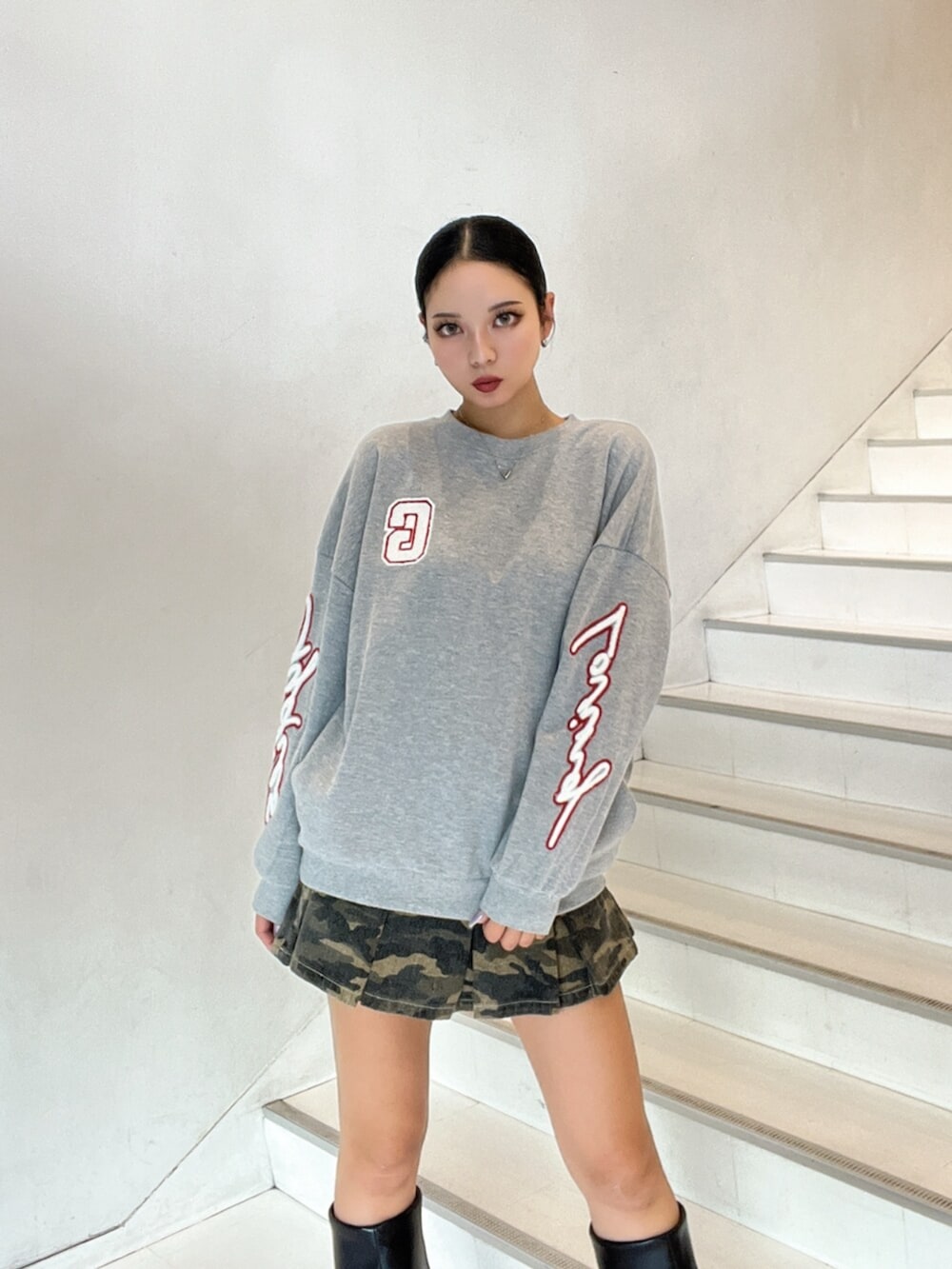 ブラック系のブーツ、グレー系のスウェット、その他のデニムスカートを着用したレディースの秋コーディネートの6枚目の写真