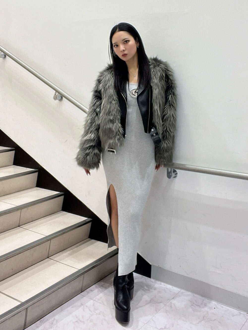 ブラック系のブーツ、グレー系のワンピース、グレー系のライダースジャケットを着用したレディースの冬コーディネートの2枚目の写真