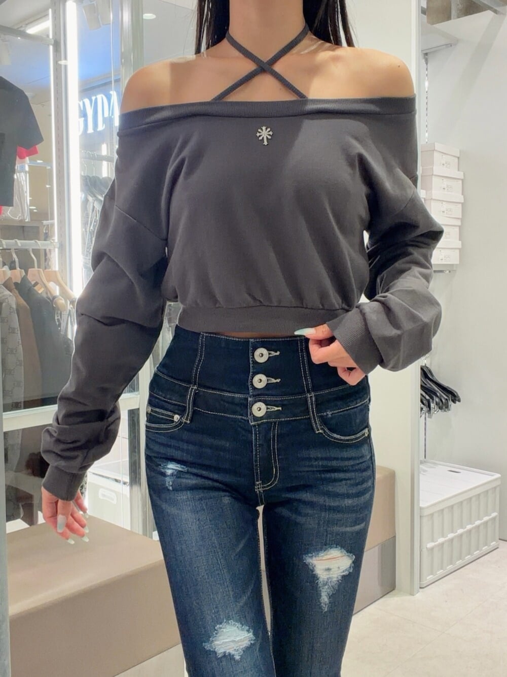 シルバー系のパンプス、ブルー系のデニムパンツ、グレー系のスウェットを着用したレディースの秋コーディネートの5枚目の写真