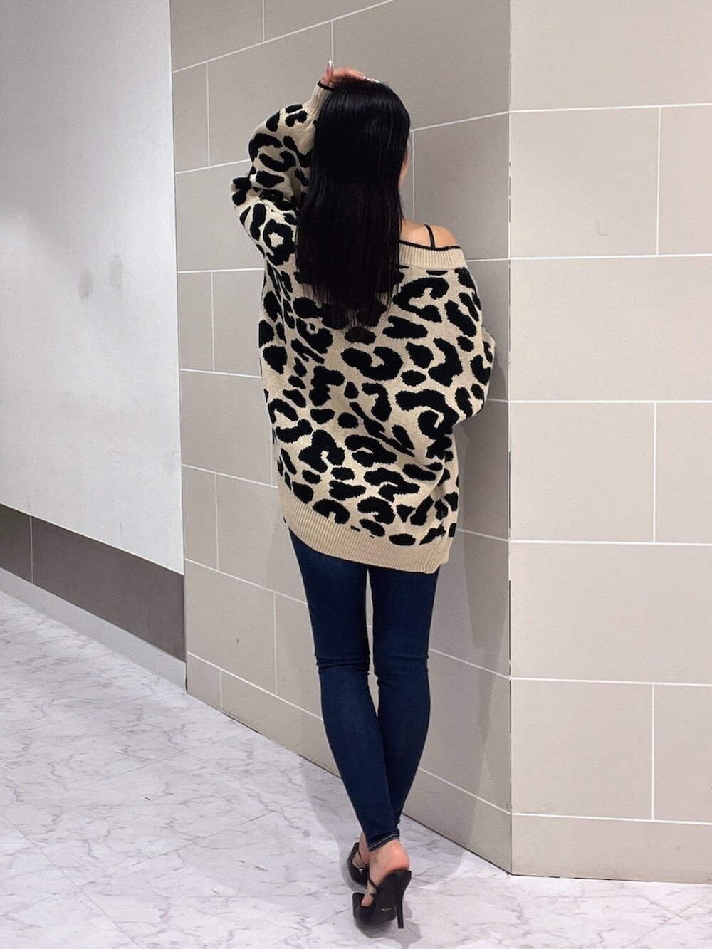 ブラック系のキャミソール、ブラック系のパンプス、ブルー系のデニムパンツを着用したレディースの春コーディネートの5枚目の写真