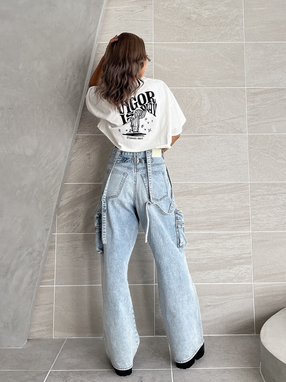 ホワイト系のTシャツ/カットソー、ブルー系のデニムパンツ、ブラック系のブーツを着用したレディースの夏コーディネートの5枚目の写真