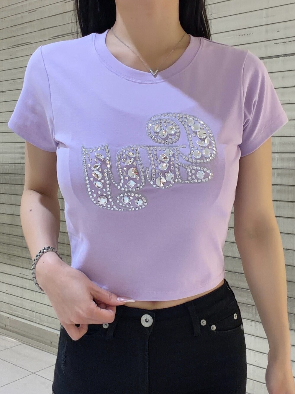 パープル系のTシャツ/カットソー、ブラック系のデニムパンツ、シルバー系のハンドバッグを着用したレディースの春コーディネートの5枚目の写真