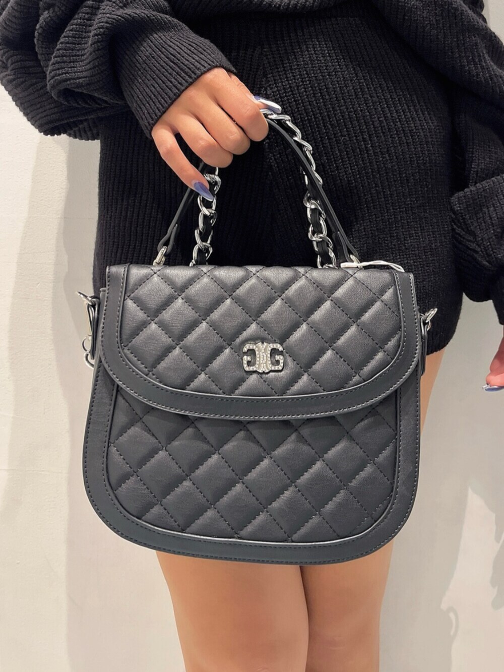 ブラック系のブーツ、ブラック系のハンドバッグ、ブラック系のつなぎ/オールインワンを着用したレディースの秋コーディネートの7枚目の写真