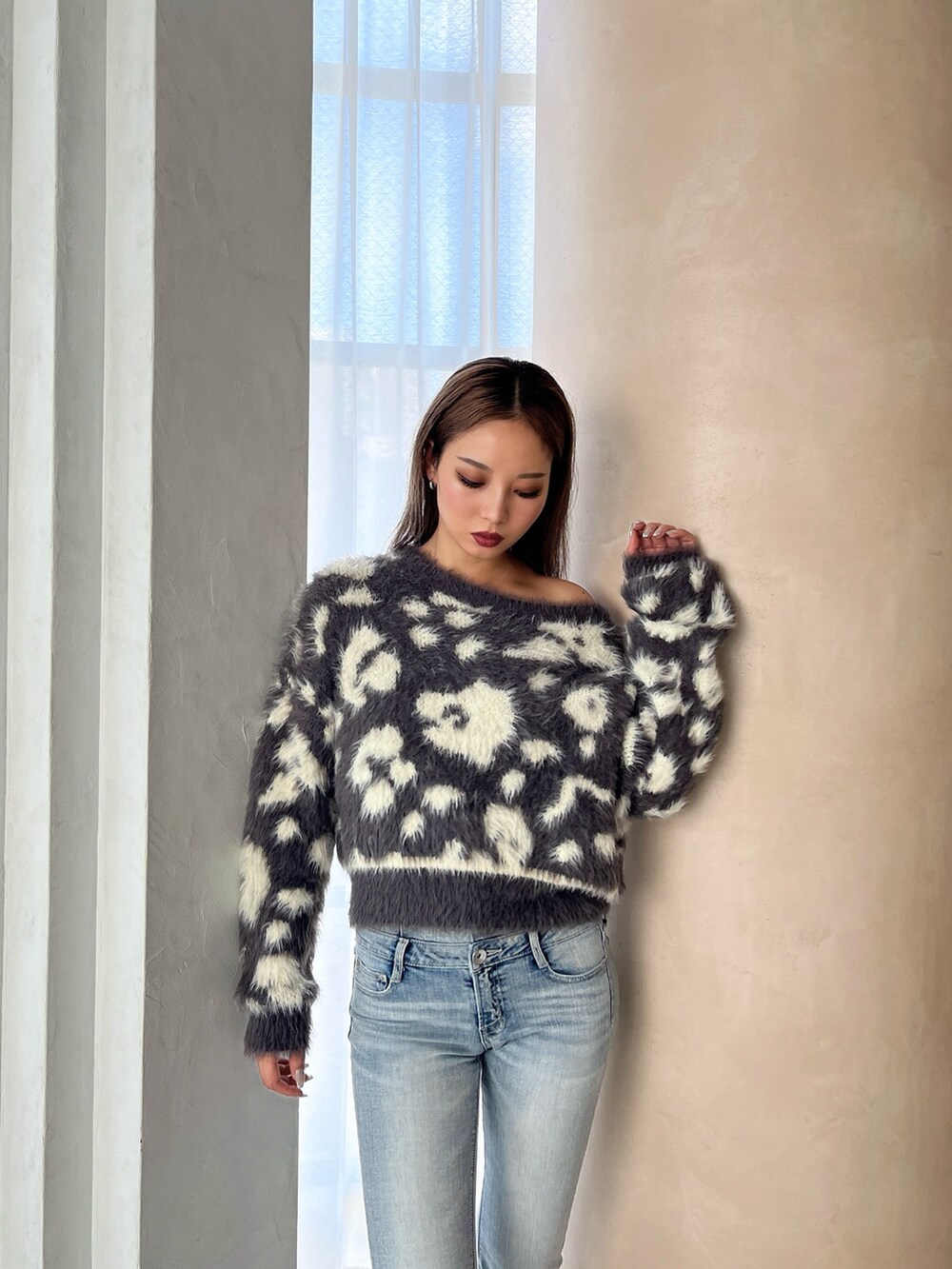 グレー系のニット/セーター、ブルー系のデニムパンツ、ホワイト系のパンプスを着用したレディースの冬コーディネートの4枚目の写真