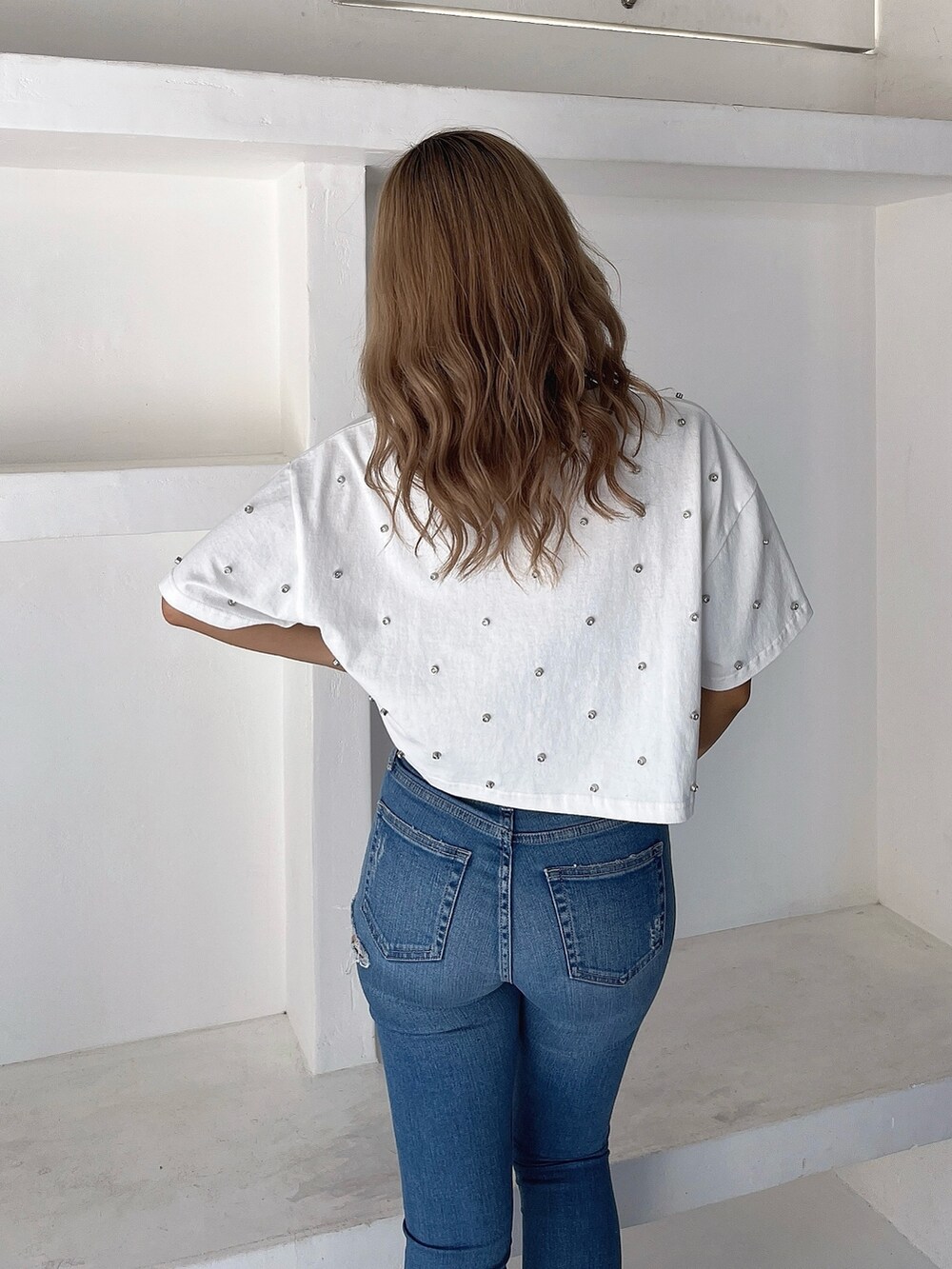 ホワイト系のTシャツ/カットソー、ブルー系のデニムパンツ、ブラック系のサンダルを着用したレディースの春コーディネートの4枚目の写真