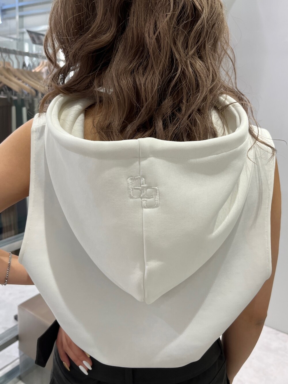 ホワイト系のパーカー、グレー系のスカート、ブラック系のブーツを着用したレディースの夏コーディネートの4枚目の写真