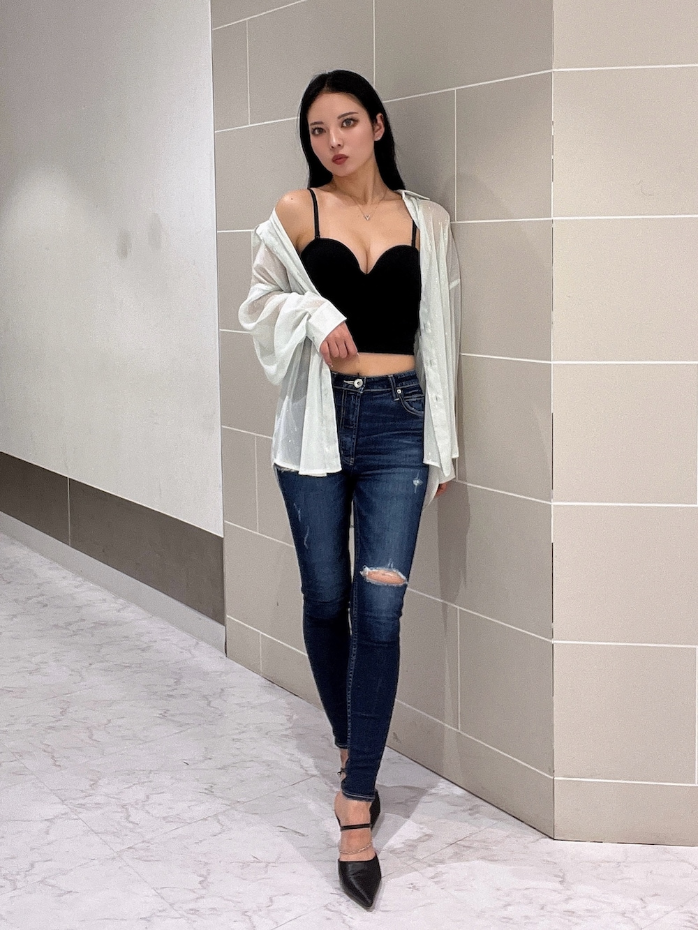 ブラック系のキャミソール、ブルー系のデニムパンツ、ブラック系のパンプスを着用したレディースの春コーディネートの3枚目の写真