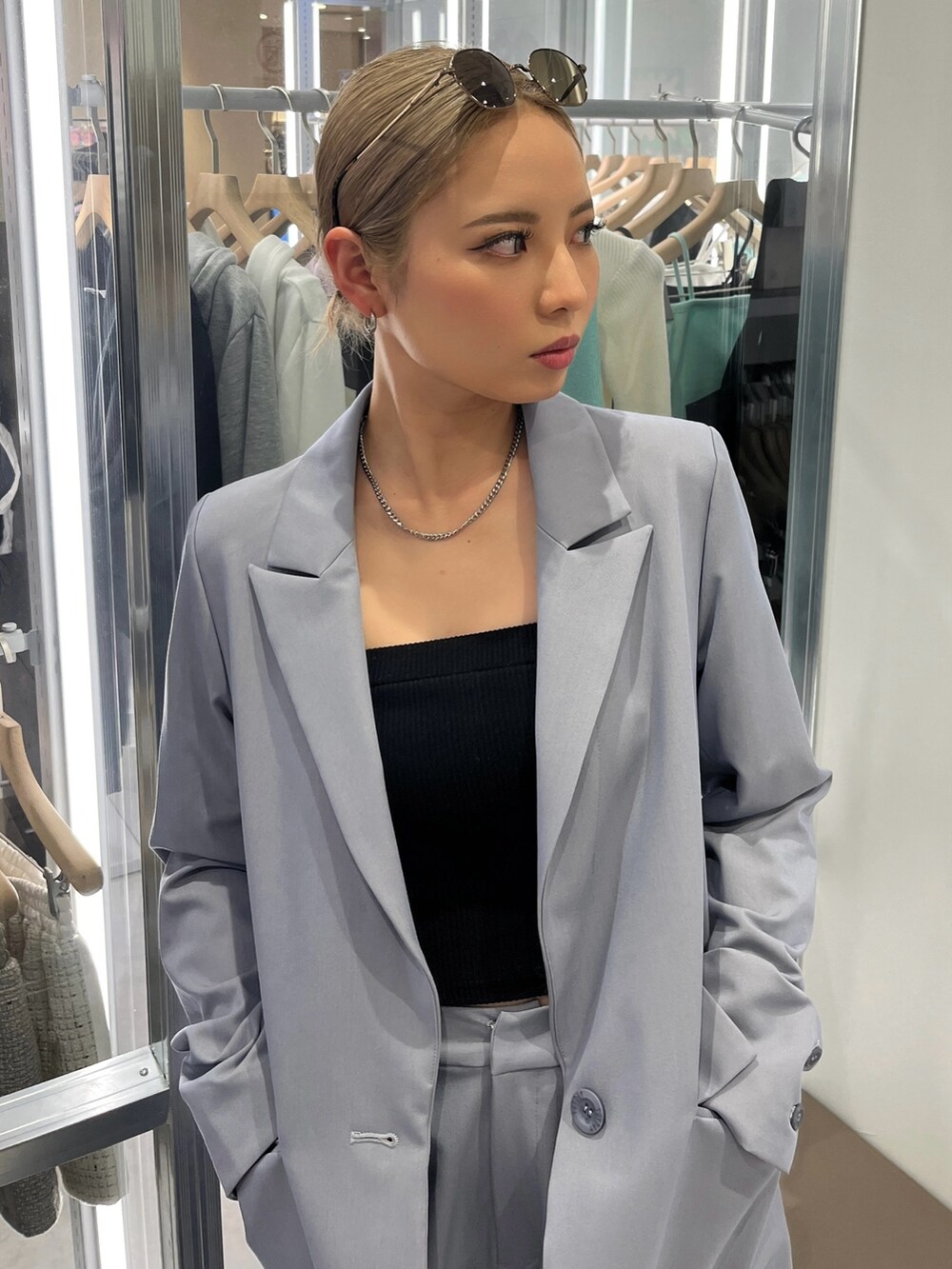 ブルー系のテーラードジャケット、ブルー系のその他パンツ、ブラック系のキャミソールを着用したレディースの春コーディネートの2枚目の写真