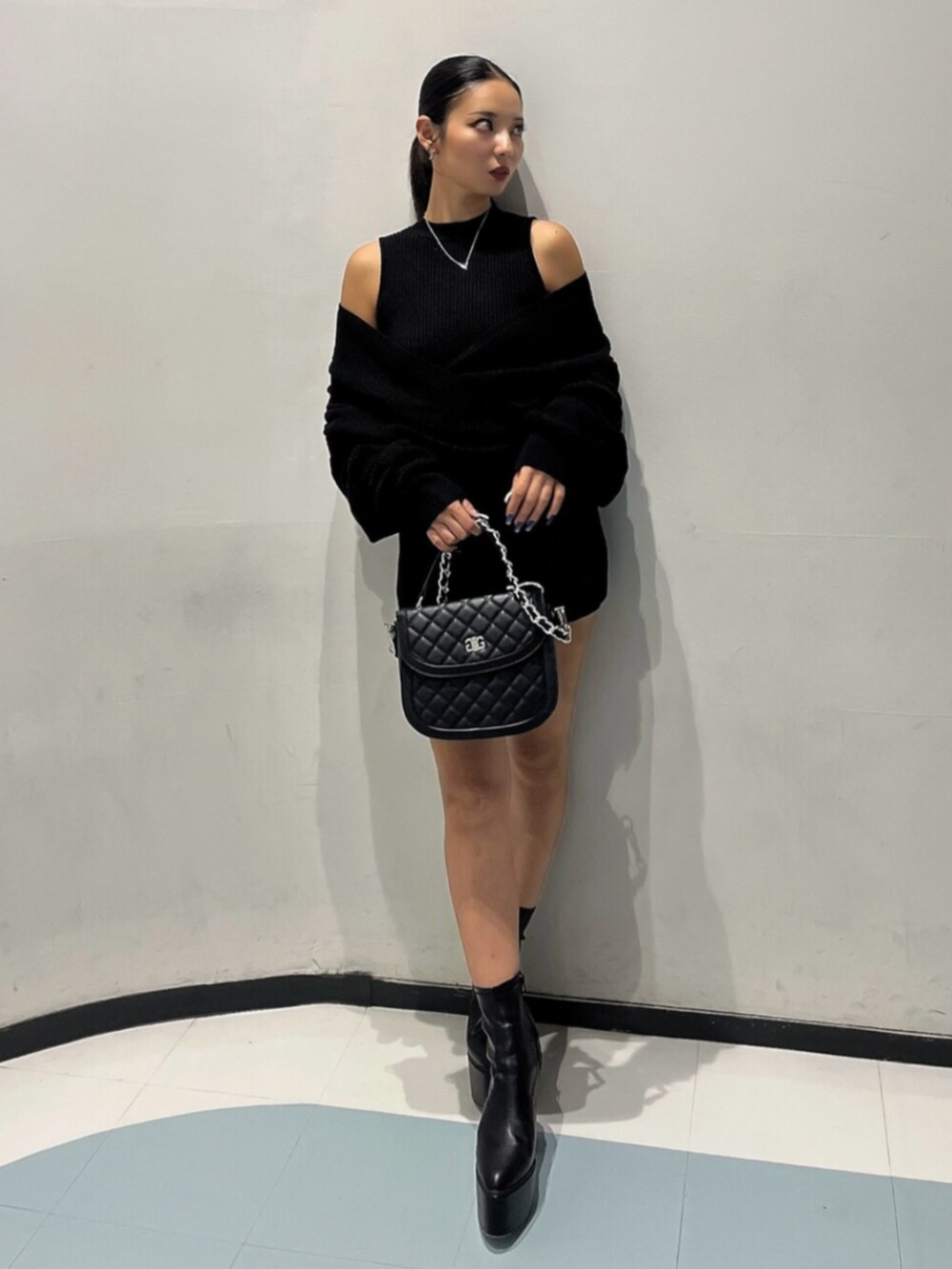 ブラック系のブーツ、ブラック系のハンドバッグ、ブラック系のつなぎ/オールインワンを着用したレディースの秋コーディネートの3枚目の写真