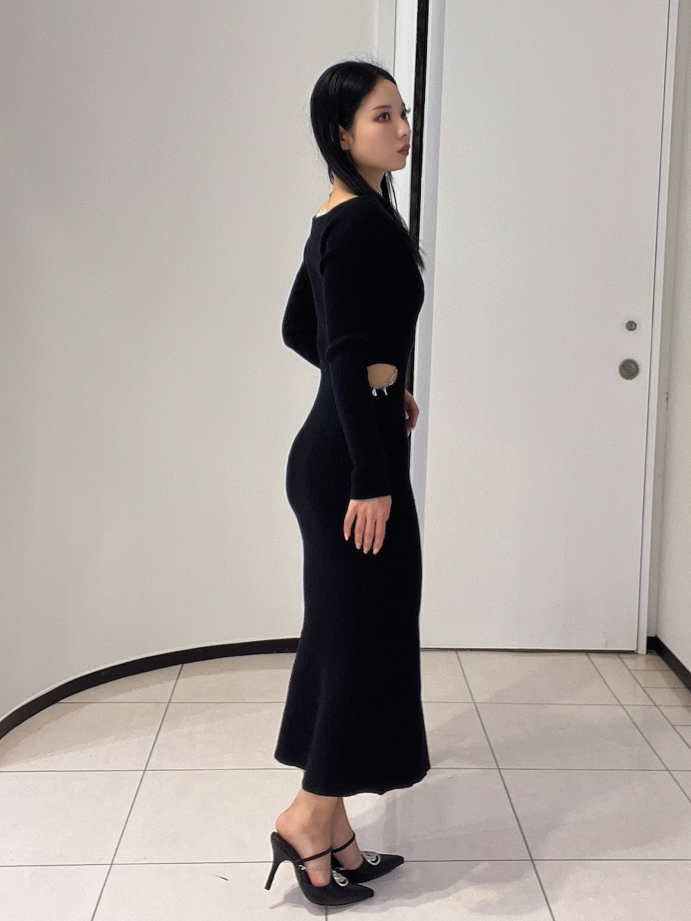 ブラック系のワンピース、ブラック系のパンプスを着用したレディースの春コーディネートの3枚目の写真