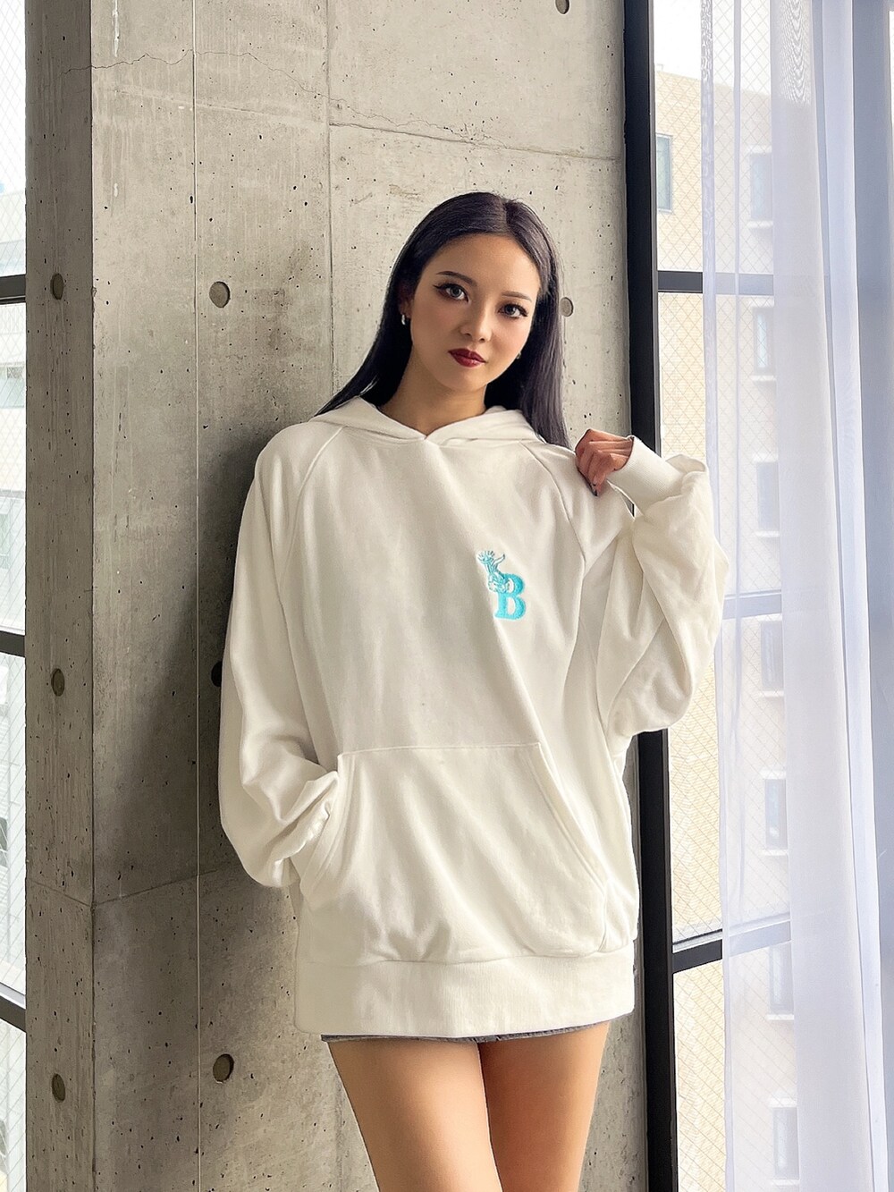 ホワイト系のパーカーを着用したレディースの冬コーディネートの2枚目の写真