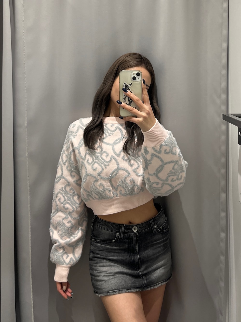 ピンク系のニット/セーター、ブラック系のデニムスカート、ブラック系のブーツを着用したレディースの冬コーディネートの2枚目の写真