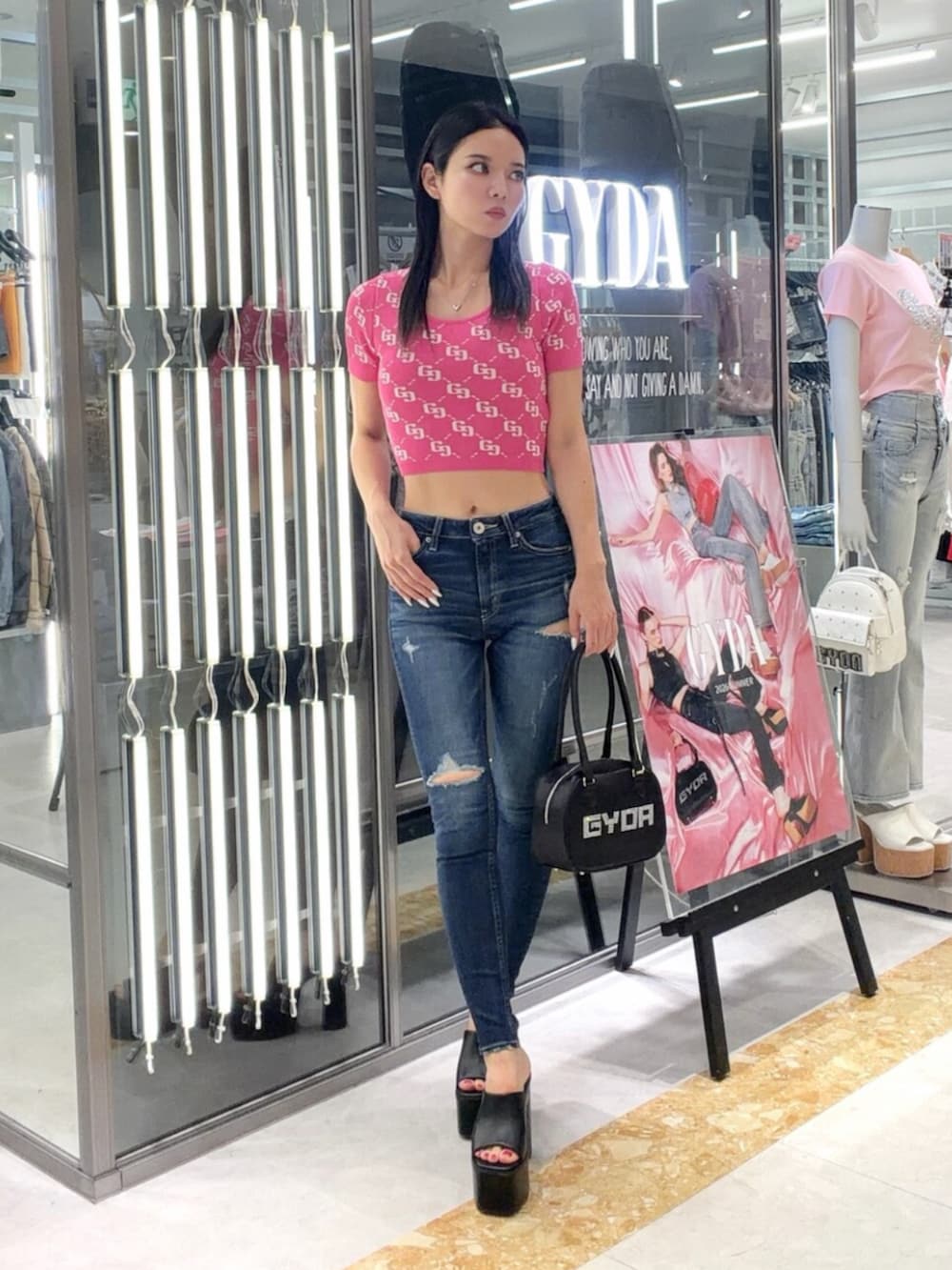 ブラック系のサンダル、ブルー系のデニムパンツ、ピンク系のニット/セーターを着用したレディースの夏コーディネートの2枚目の写真
