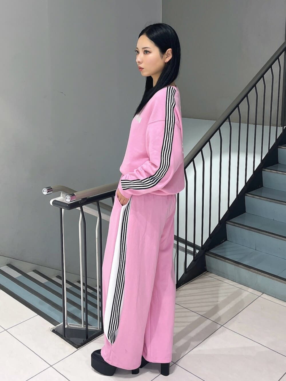 ブラック系のブーツ、ピンク系のスウェット、ピンク系のスウェットパンツを着用したレディースの冬コーディネートの4枚目の写真