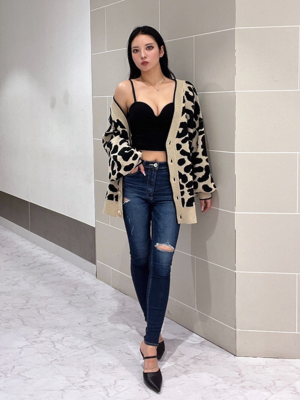 ブラック系のキャミソール、ブラック系のパンプス、ブルー系のデニムパンツを着用したレディースの春コーディネートの2枚目の写真