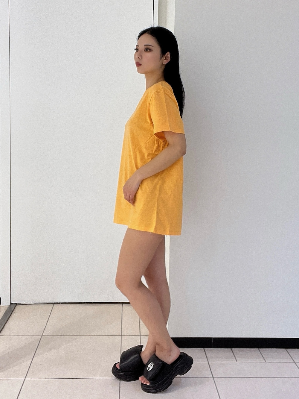 オレンジ系のTシャツ/カットソー、ブルー系のデニムパンツを着用したレディースの春コーディネートの3枚目の写真