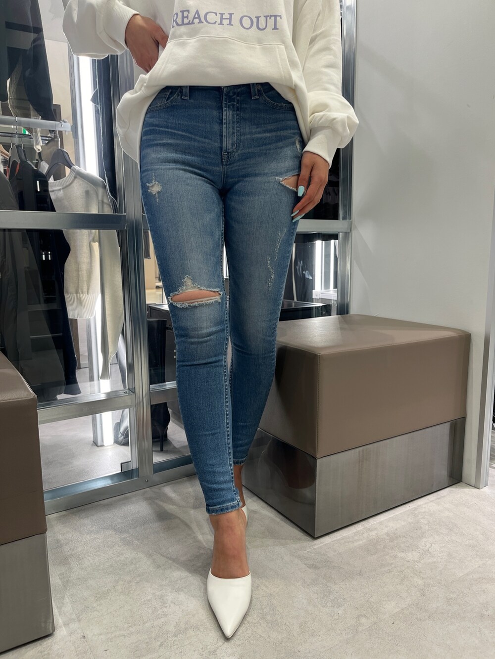 ホワイト系のパーカー、ブルー系のデニムパンツ、ホワイト系のパンプスを着用したレディースの冬コーディネートの5枚目の写真