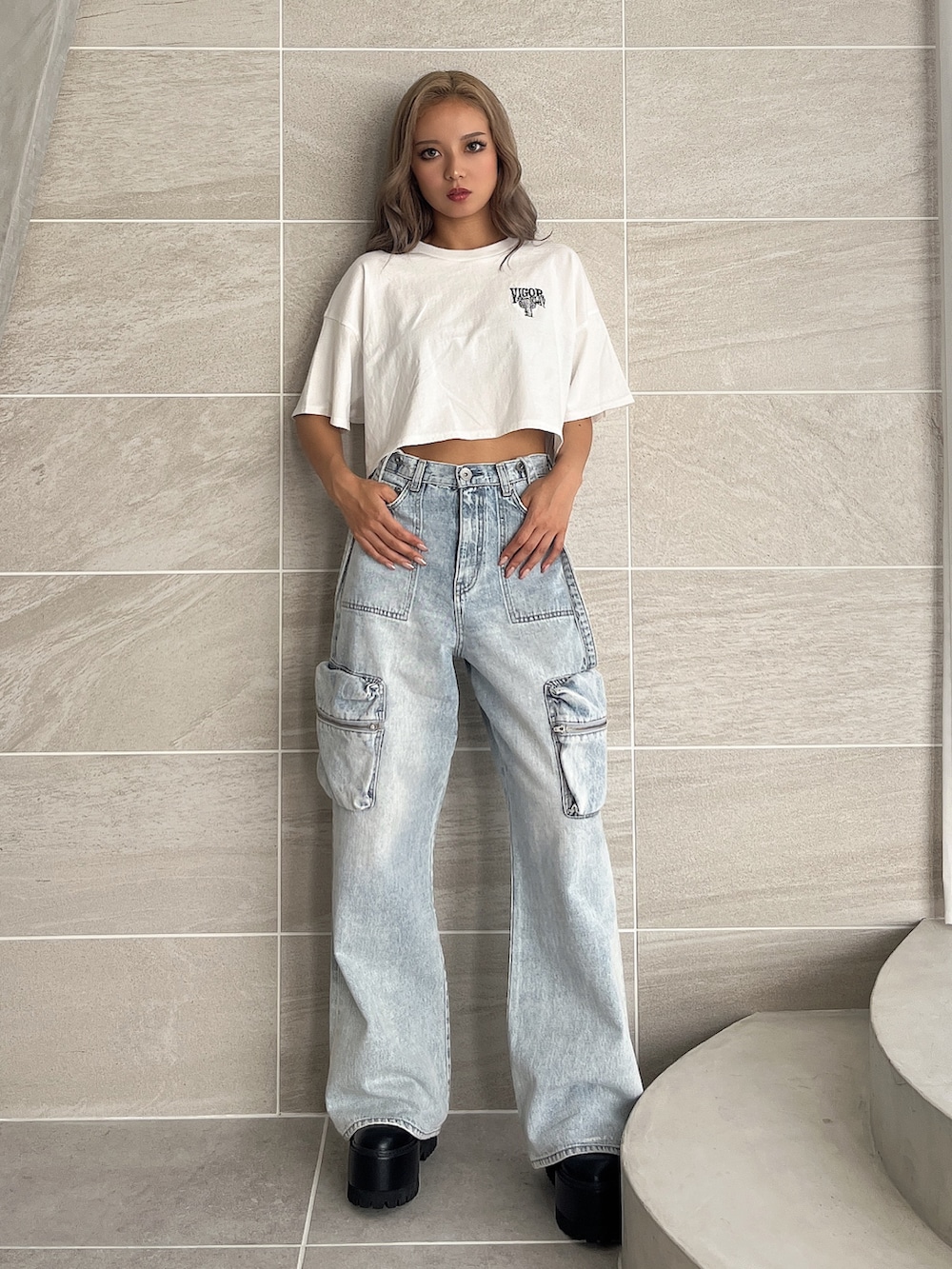 ホワイト系のTシャツ/カットソー、ブルー系のデニムパンツ、ブラック系のブーツを着用したレディースの夏コーディネートの2枚目の写真
