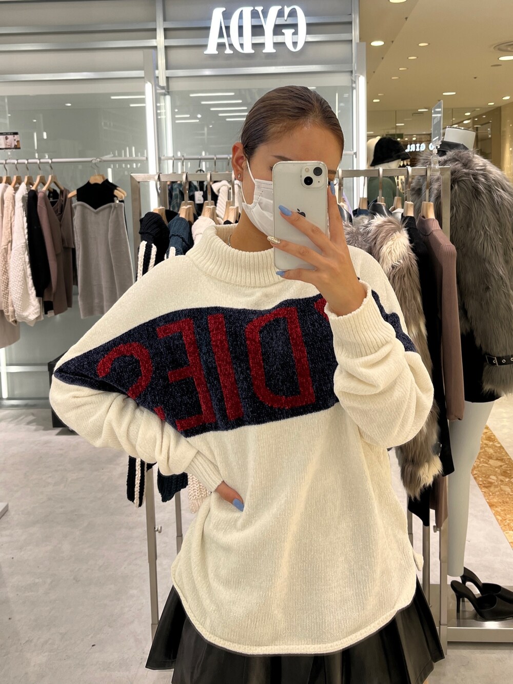 ホワイト系のニット/セーター、ブラック系のスカート、ブラック系のブーツを着用したレディースの秋コーディネートの3枚目の写真