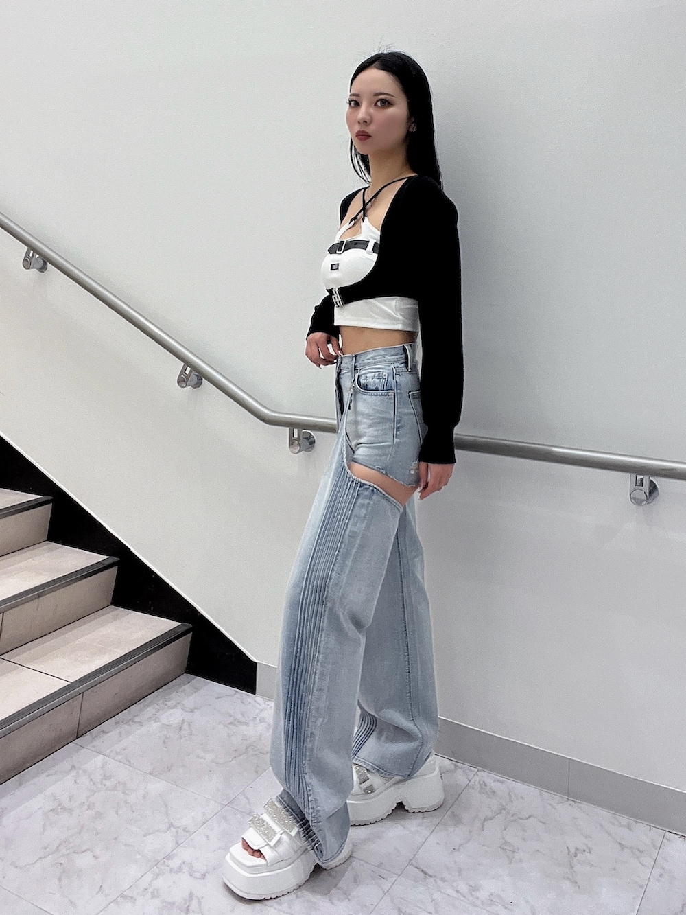 ホワイト系のキャミソール、ブラック系のカーディガン/ボレロ、ブルー系のデニムパンツを着用したレディースの春コーディネートの3枚目の写真