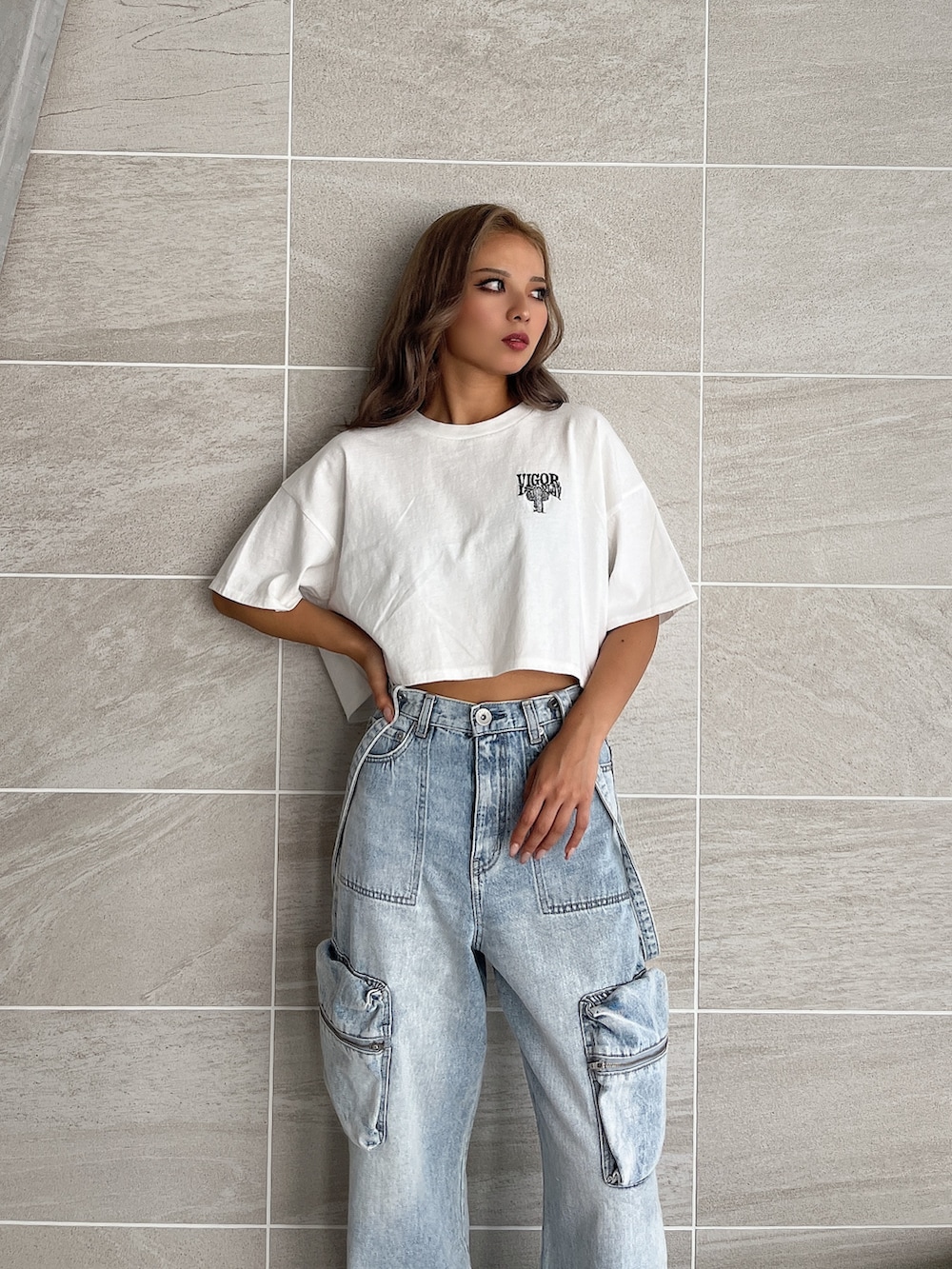 ホワイト系のTシャツ/カットソー、ブルー系のデニムパンツ、ブラック系のブーツを着用したレディースの夏コーディネートの6枚目の写真