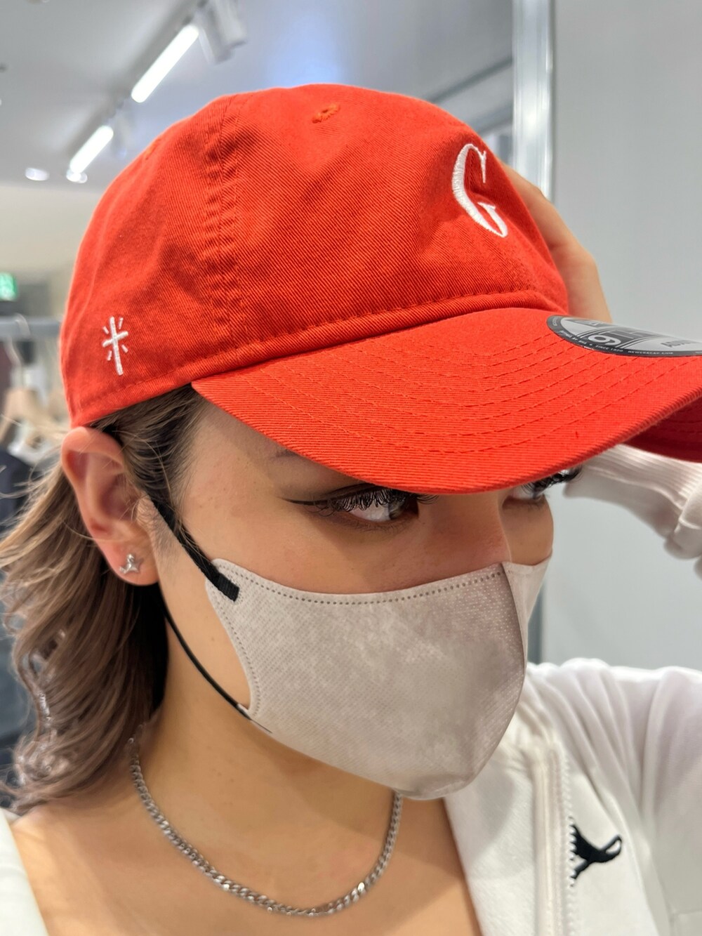 ホワイト系のパーカー、ブラック系のキャミソール、グレー系のスカートを着用したレディースの冬コーディネートの5枚目の写真