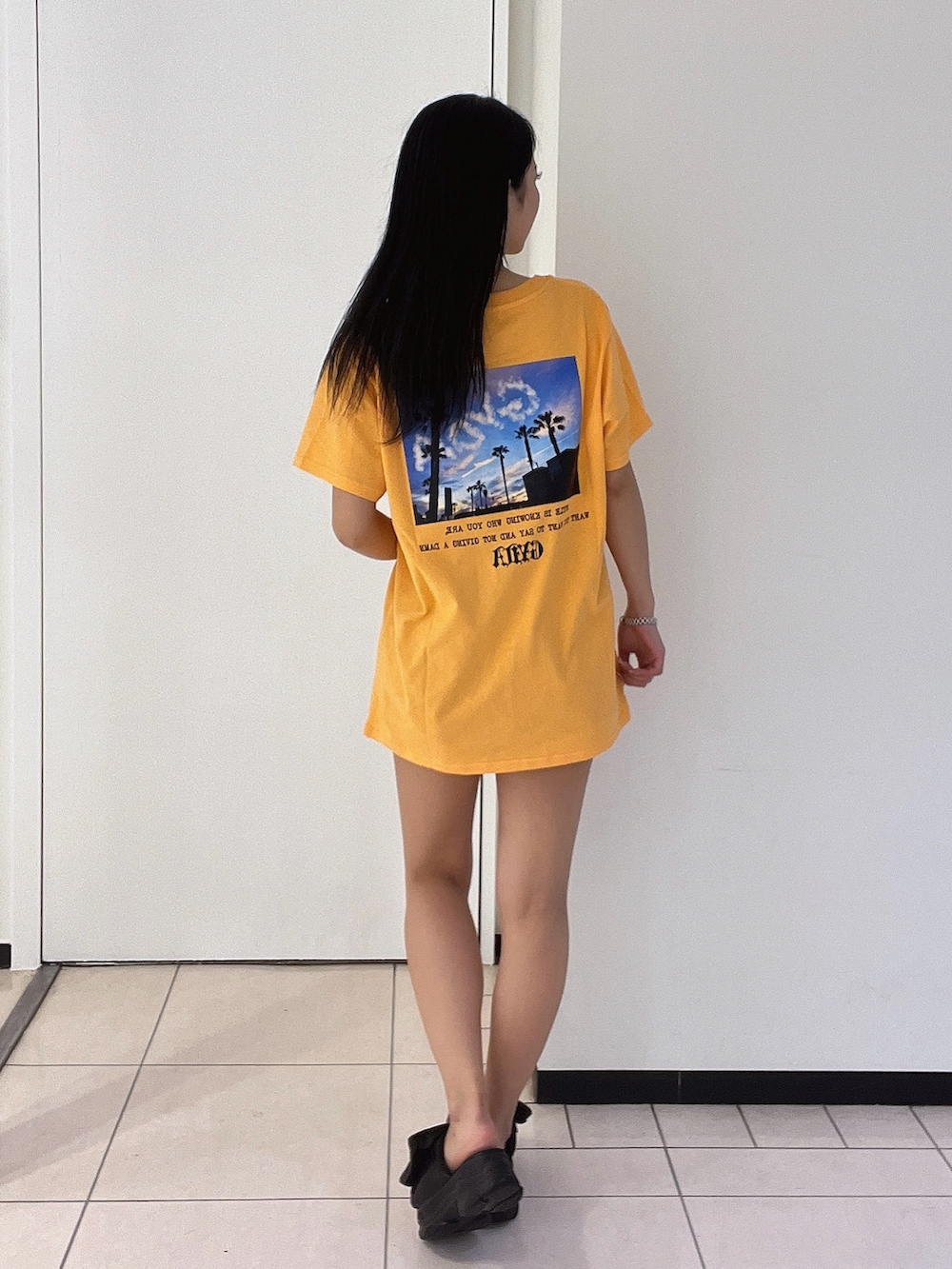 オレンジ系のTシャツ/カットソー、ブルー系のデニムパンツを着用したレディースの春コーディネートの4枚目の写真