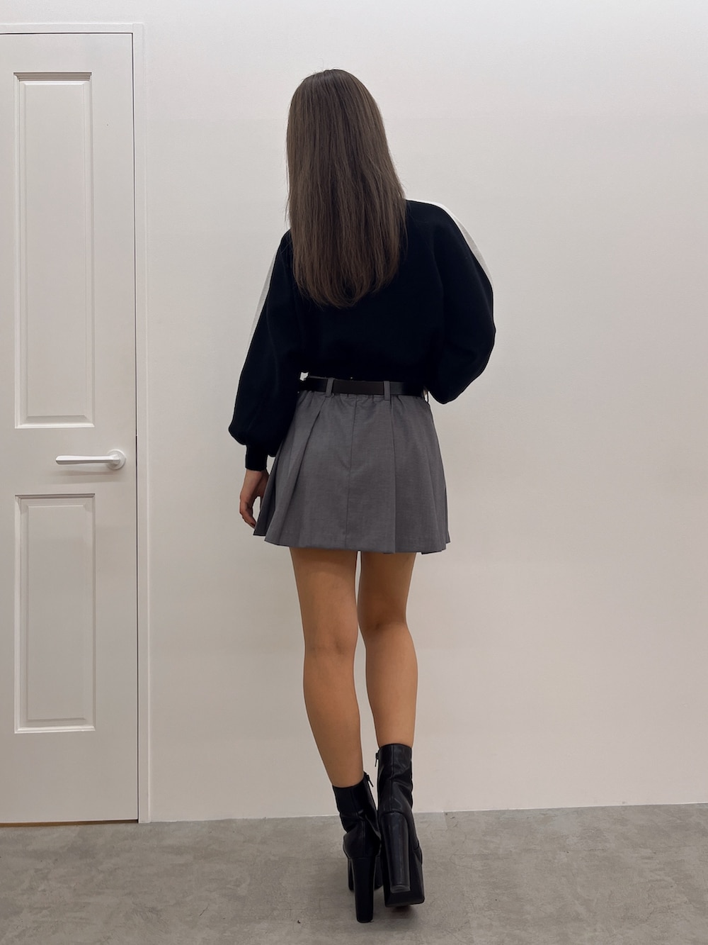 ブラック系のニット/セーター、グレー系のスカート、ブラック系のブーツを着用したレディースの冬コーディネートの3枚目の写真