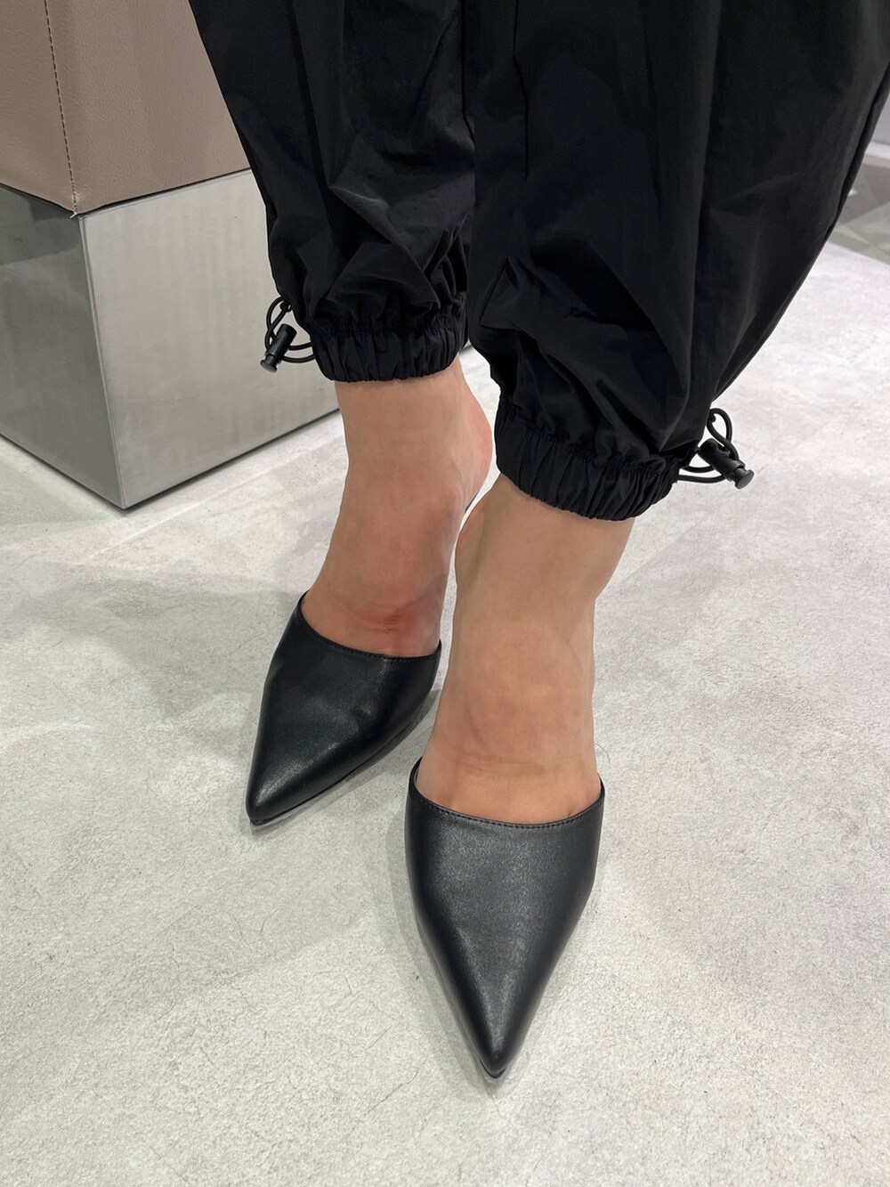 ブラック系のカーゴパンツ、ブラック系のパンプス、その他のタンクトップを着用したレディースの夏コーディネートの6枚目の写真