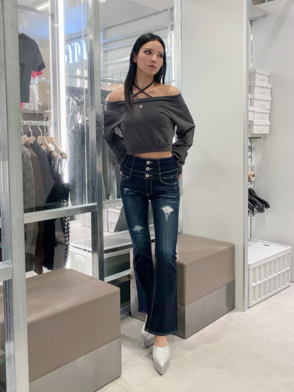 シルバー系のパンプス、ブルー系のデニムパンツ、グレー系のスウェットを着用したレディースの秋コーディネートの2枚目の写真