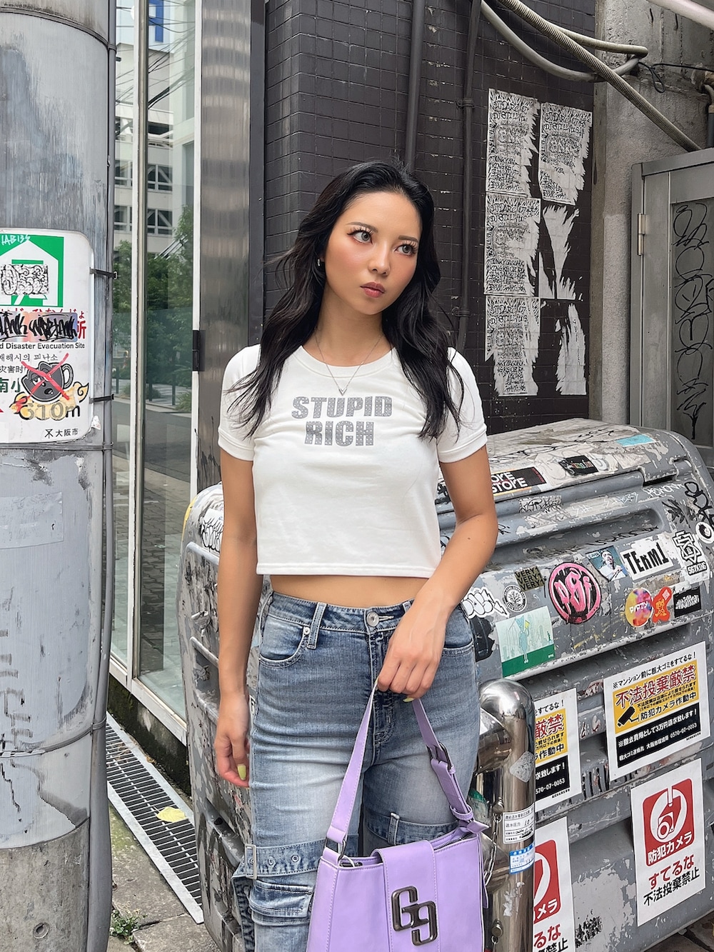 ホワイト系のTシャツ/カットソー、ブルー系のデニムパンツ、パープル系のハンドバッグを着用したレディースの夏コーディネートの3枚目の写真