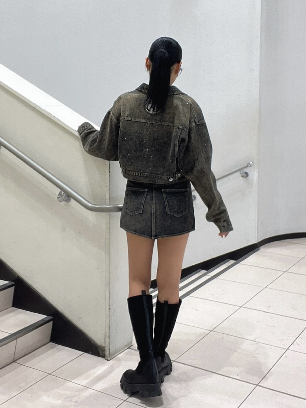 ブラック系のブーツ、ブラック系のTシャツ/カットソー、ブルー系のデニムジャケットを着用したレディースの秋コーディネートの3枚目の写真