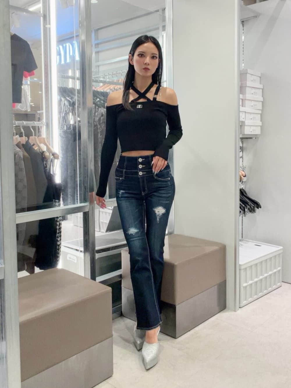 シルバー系のパンプス、ブルー系のデニムパンツ、ブラック系のニット/セーターを着用したレディースの秋コーディネートの2枚目の写真