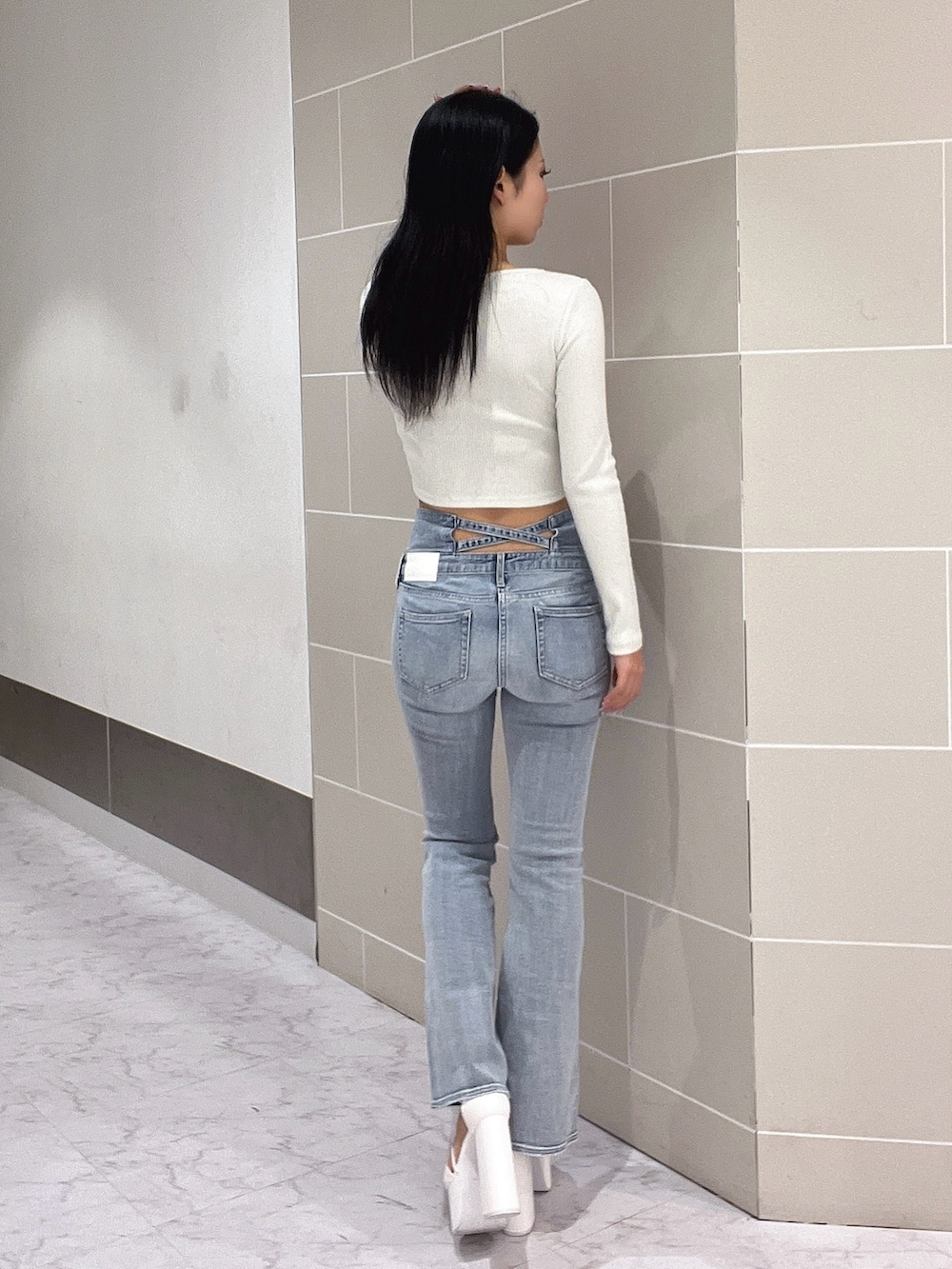 ホワイト系のTシャツ/カットソー、ブルー系のデニムパンツ、ホワイト系のサンダルを着用したレディースの春コーディネートの4枚目の写真